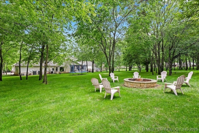 20565 E Clear Brook Rd, Owasso, OK 74055 - view of grassy yard with an outdoor fire pit and view of wooded area