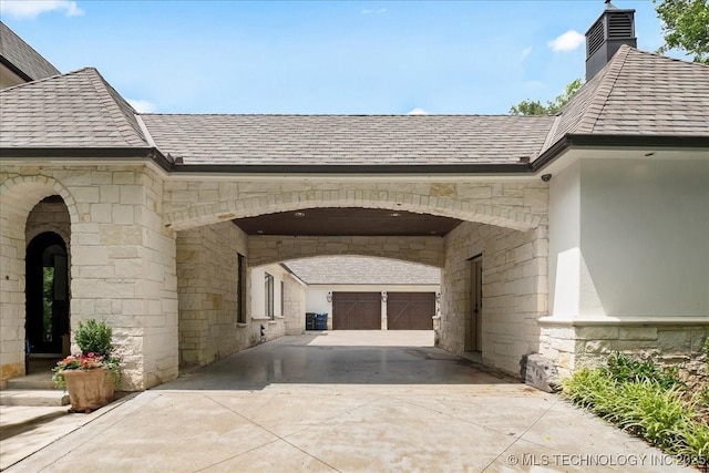 20565 E Clear Brook Rd, Owasso, OK 74055 - property entrance with driveway, stone siding, and a chimney