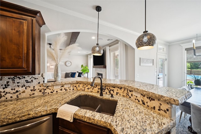14400 E Willow Way, Claremore, OK 74019 - kitchen with dishwasher, light stone counters, dark brown cabinetry, arched walkways, and backsplash
