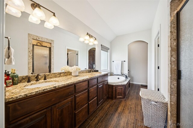 14400 E Willow Way, Claremore, OK 74019 - bathroom featuring a shower stall, wood finished floors, double vanity, a garden tub, and vaulted ceiling