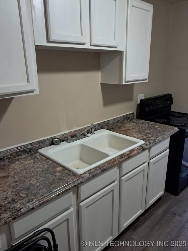327 Ash, Ardmore, OK 73401 - kitchen featuring black range with electric stovetop, white cabinets, and dark wood finished floors