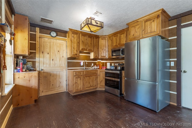 46367 County Road 553, Colcord, OK 74338 - kitchen featuring appliances with stainless steel finishes, dark wood finished floors, light countertops, and brown cabinets