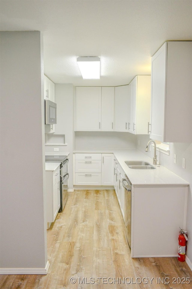 3180 E 2090th Rd, Hugo, OK 74743 - kitchen with appliances with stainless steel finishes, light wood finished floors, and white cabinetry