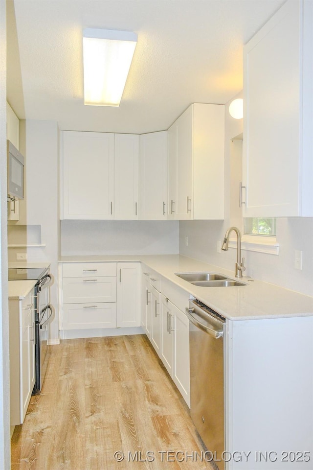 3180 E 2090th Rd, Hugo, OK 74743 - kitchen with appliances with stainless steel finishes, white cabinets, light wood-style flooring, and light countertops