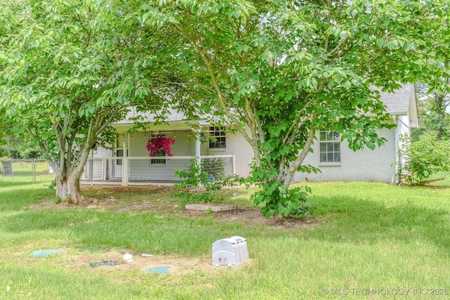 3180 E 2090th Rd, Hugo, OK 74743 - view of property hidden behind natural elements featuring a porch, roof with shingles, and brick siding