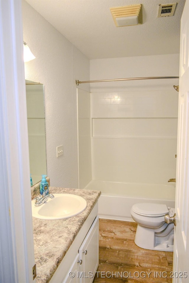3180 E 2090th Rd, Hugo, OK 74743 - bathroom with vanity, wood finished floors, bathtub / shower combination, and a textured wall