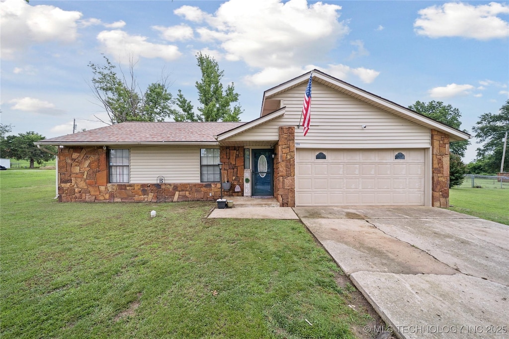 128 Elm St, Mannford, OK 74044 - view of front of home featuring stone siding, an attached garage, driveway, and a front yard