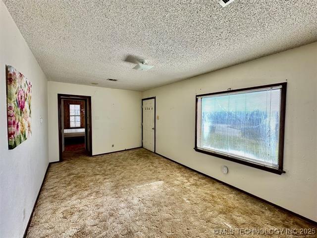 1305 7th Ave NW, Ardmore, OK 73401 - unfurnished room featuring a textured ceiling and carpet floors