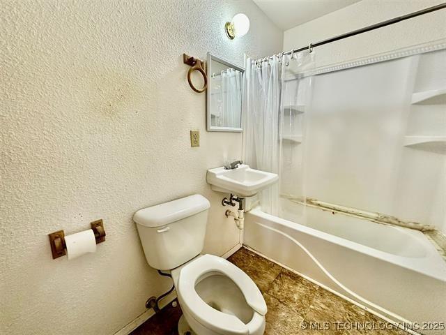 1305 7th Ave NW, Ardmore, OK 73401 - full bath featuring shower / bathtub combination with curtain and a textured wall