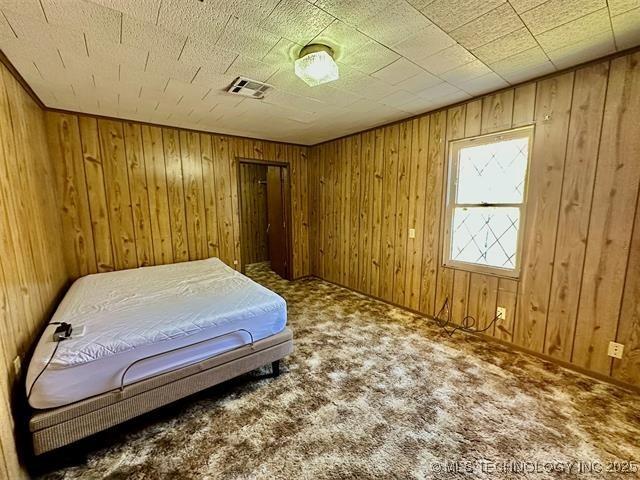1305 7th Ave NW, Ardmore, OK 73401 - carpeted bedroom with wood walls