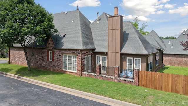 7721 E 101st Pl, Tulsa, OK 74133 - rear view of house with brick siding, a chimney, board and batten siding, and a shingled roof