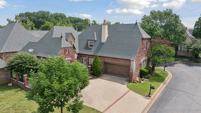 7721 E 101st Pl, Tulsa, OK 74133 - view of front of property with brick siding, concrete driveway, a chimney, and an attached garage