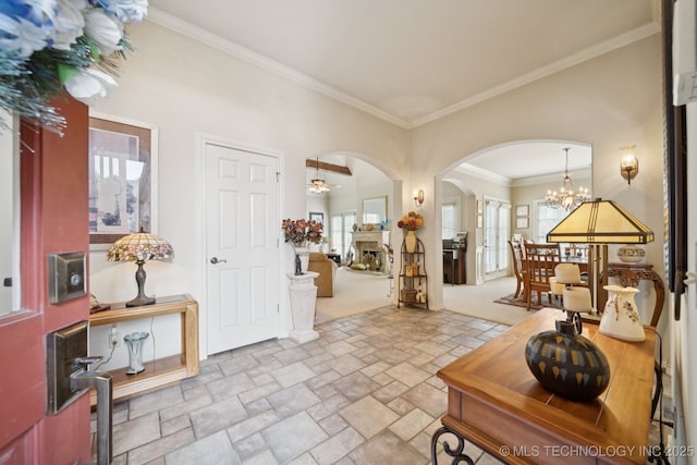 7721 E 101st Pl, Tulsa, OK 74133 - foyer entrance with arched walkways, stone tile floors, ornamental molding, a chandelier, and ceiling fan