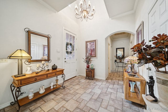 7721 E 101st Pl, Tulsa, OK 74133 - entryway featuring arched walkways, stone tile flooring, a chandelier, and crown molding
