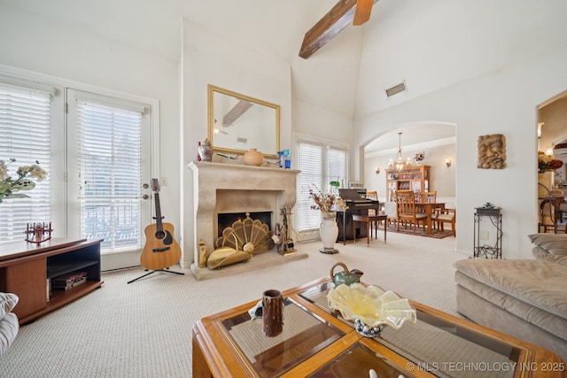 7721 E 101st Pl, Tulsa, OK 74133 - living room featuring carpet flooring, arched walkways, plenty of natural light, high vaulted ceiling, and a chandelier