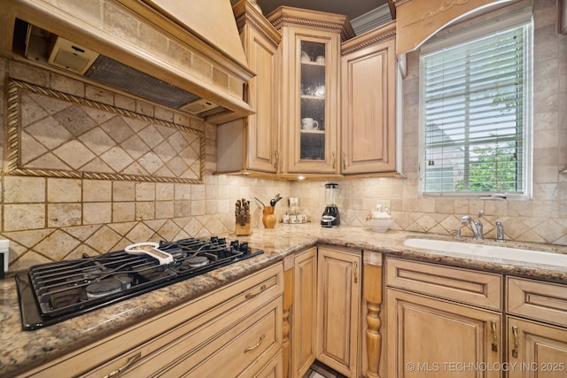 7721 E 101st Pl, Tulsa, OK 74133 - kitchen with premium range hood, black gas cooktop, decorative backsplash, light stone counters, and glass insert cabinets
