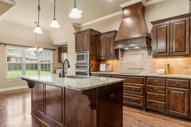 425 W 128th St S, Jenks, OK 74037 - kitchen with premium range hood, stainless steel microwave, dark wood-style floors, a breakfast bar, and a chandelier