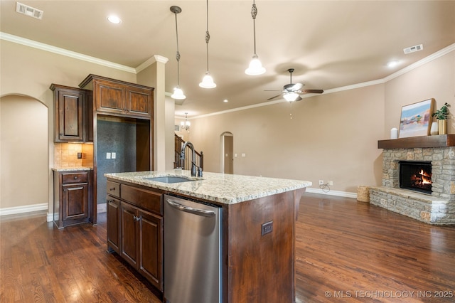 425 W 128th St S, Jenks, OK 74037 - kitchen with stainless steel dishwasher, arched walkways, a fireplace, a ceiling fan, and dark wood-style floors
