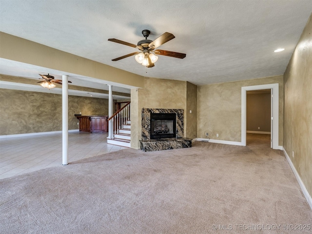 109 E Bk 800th Rd, Stigler, OK 74462 - unfurnished living room with ceiling fan, carpet floors, a high end fireplace, and stairway