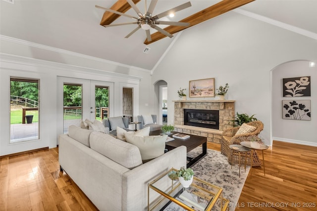 7380 Royalwood Way, Tulsa, OK 74131 - living room featuring a fireplace, beam ceiling, arched walkways, high vaulted ceiling, and ceiling fan