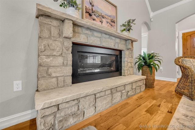 7380 Royalwood Way, Tulsa, OK 74131 - detailed view of arched walkways, a stone fireplace, crown molding, and wood finished floors