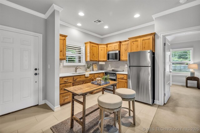 7380 Royalwood Way, Tulsa, OK 74131 - kitchen with appliances with stainless steel finishes, light countertops, crown molding, tasteful backsplash, and healthy amount of natural light