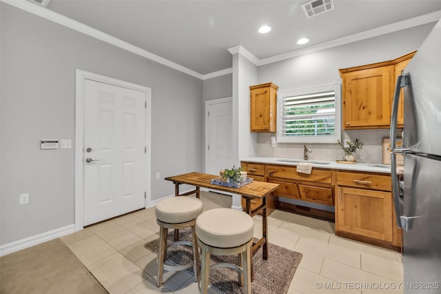 7380 Royalwood Way, Tulsa, OK 74131 - kitchen featuring freestanding refrigerator, ornamental molding, light countertops, backsplash, and light tile patterned floors