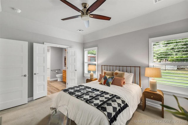 7380 Royalwood Way, Tulsa, OK 74131 - bedroom featuring multiple windows, light carpet, connected bathroom, and ceiling fan