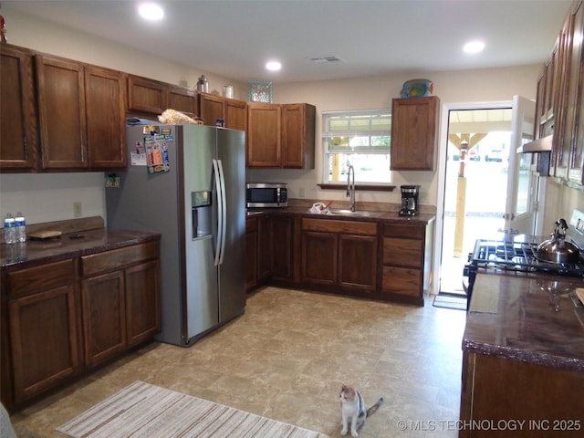 419124 E 1144th Rd, Checotah, OK 74426 - kitchen featuring stainless steel appliances, brown cabinets, recessed lighting, and dark stone countertops