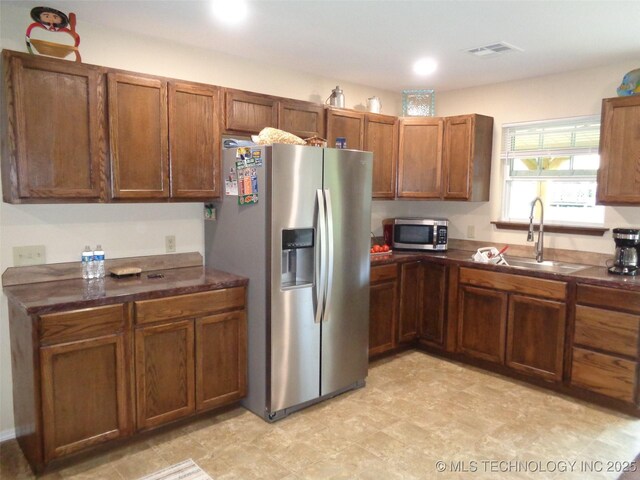 419124 E 1144th Rd, Checotah, OK 74426 - kitchen with stainless steel appliances, dark countertops, brown cabinetry, recessed lighting, and light floors