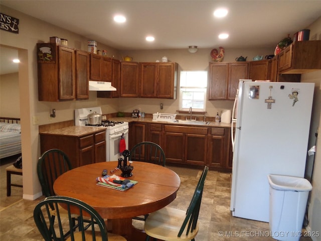 419124 E 1144th Rd, Checotah, OK 74426 - kitchen featuring white appliances, under cabinet range hood, recessed lighting, and brown cabinets