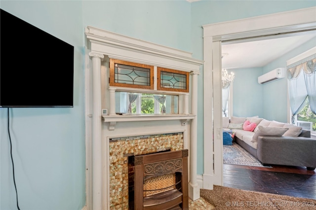 415 S 13th St, Muskogee, OK 74401 - living area featuring an AC wall unit, wood finished floors, a chandelier, and a fireplace