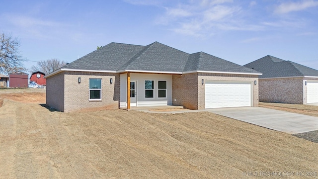 4081 W Highland Park Dr, Cleveland, OK 74020 - view of front of home featuring brick siding, an attached garage, concrete driveway, and roof with shingles