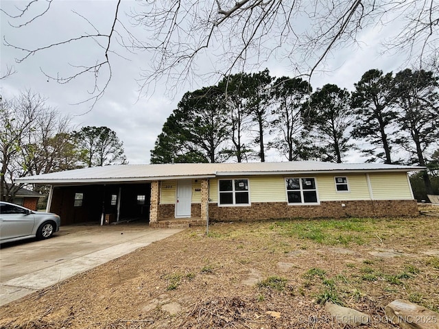 305 NW 4th St Unit 1/2, Wilburton, OK 74578 - view of front of home featuring a carport, brick siding, driveway, and a metal roof