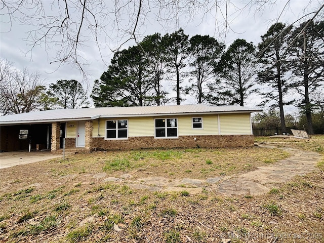 305 NW 4th St Unit 1/2, Wilburton, OK 74578 - view of front facade with a carport, a metal roof, and brick siding