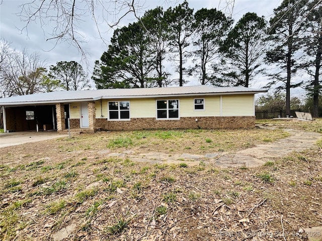 305 NW 4th St Unit 1/2, Wilburton, OK 74578 - view of front of home with brick siding, an attached carport, a metal roof, and concrete driveway