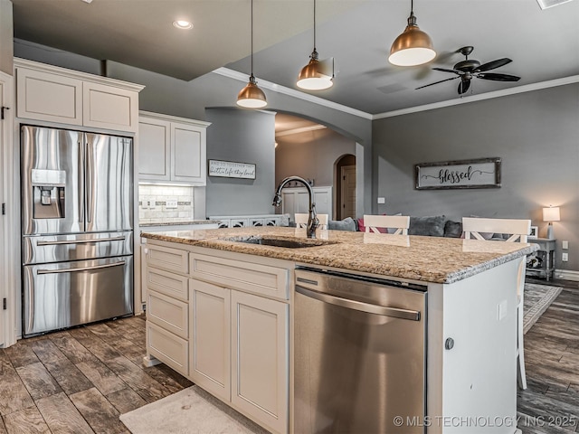 7616 E 84th St, Owasso, OK 74021 - kitchen with appliances with stainless steel finishes, arched walkways, ceiling fan, dark wood-type flooring, and crown molding