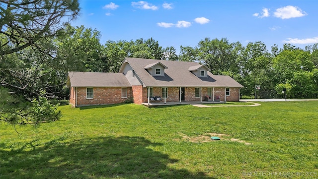 9644 Ew 19 Rd, Nowata, OK 74048 - cape cod-style house with a porch, brick siding, a front yard, and view of wooded area