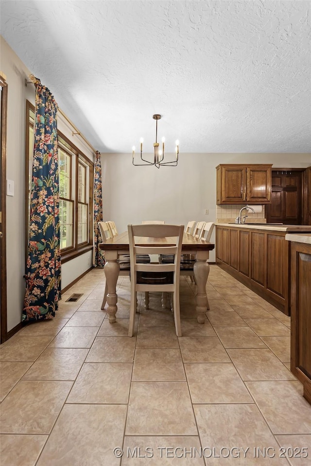 9644 Ew 19 Rd, Nowata, OK 74048 - dining room featuring a chandelier, a textured ceiling, and light tile patterned floors