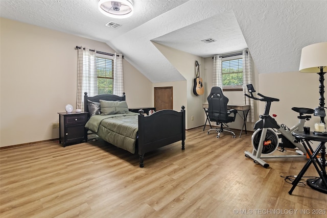 9644 Ew 19 Rd, Nowata, OK 74048 - bedroom featuring a textured ceiling, light wood-style floors, and lofted ceiling