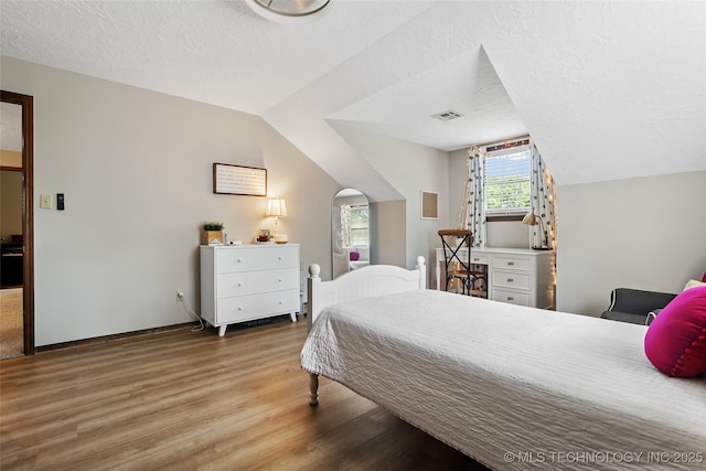 9644 Ew 19 Rd, Nowata, OK 74048 - bedroom featuring wood finished floors, a textured ceiling, and vaulted ceiling