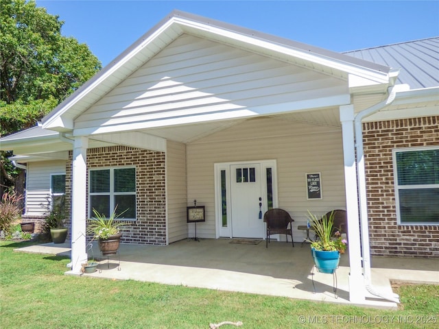 414467 E 1090th Rd, Checotah, OK 74426 - rear view of house featuring brick siding, a patio area, and a metal roof