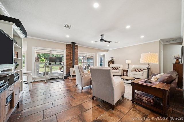 12920 E 183rd St S, Bixby, OK 74008 - living room featuring ceiling fan, crown molding, recessed lighting, a wood stove, and stone tile flooring