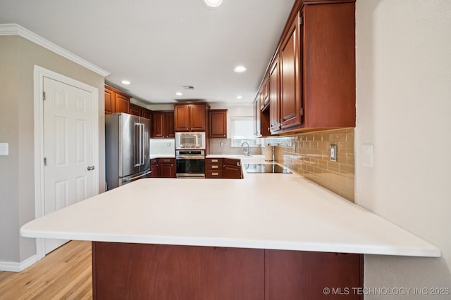 12920 E 183rd St S, Bixby, OK 74008 - kitchen featuring appliances with stainless steel finishes, light countertops, ornamental molding, a peninsula, and backsplash