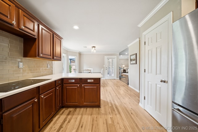 12920 E 183rd St S, Bixby, OK 74008 - kitchen with freestanding refrigerator, black electric stovetop, ornamental molding, light wood-style floors, and light countertops