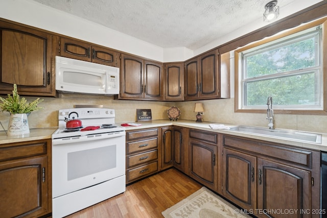 18005 S 4185th Rd, Claremore, OK 74017 - kitchen with white appliances, light countertops, light wood-style floors, tasteful backsplash, and a textured ceiling