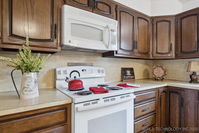 18005 S 4185th Rd, Claremore, OK 74017 - kitchen with white appliances, light countertops, backsplash, and dark brown cabinets