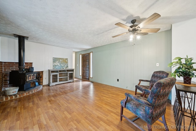 18005 S 4185th Rd, Claremore, OK 74017 - living area with wood finished floors, ceiling fan, a wood stove, and a textured ceiling