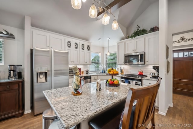 2402 W Kingsport Ct S, Broken Arrow, OK 74011 - kitchen featuring stainless steel appliances, a breakfast bar, tasteful backsplash, light wood-style floors, and high vaulted ceiling