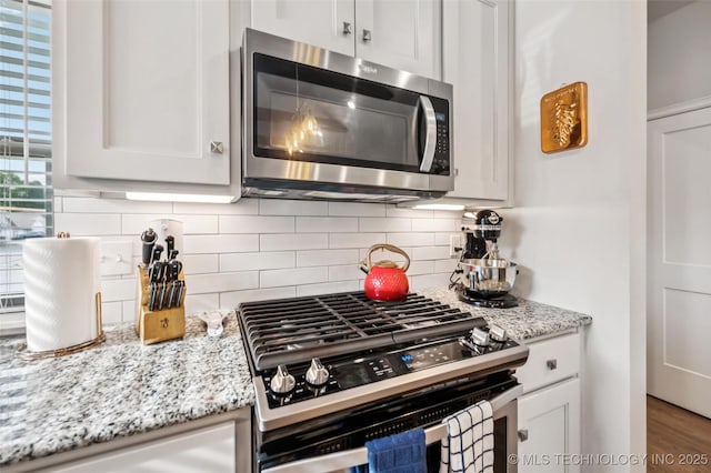 2402 W Kingsport Ct S, Broken Arrow, OK 74011 - kitchen with stainless steel appliances, decorative backsplash, white cabinets, and light stone counters